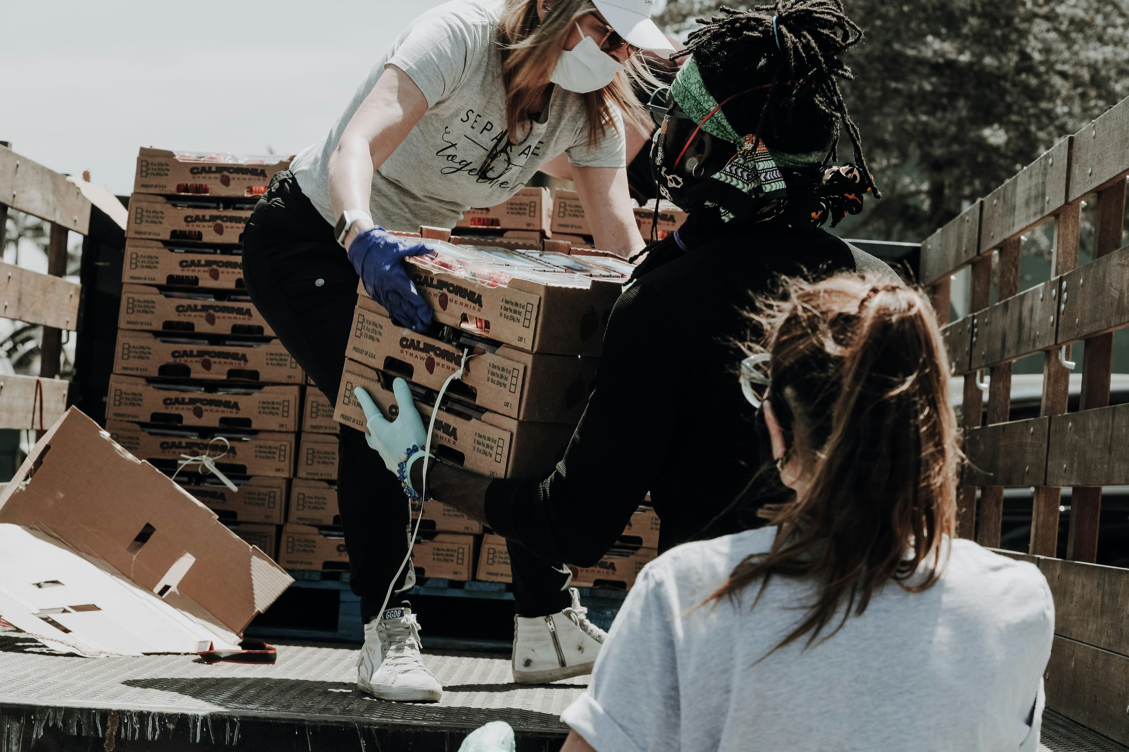 Group of volunteers moving boxes from a truck.